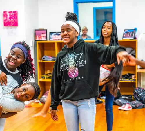 A group of youth smiling, holding hands and playing together