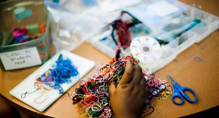 Hand holding colored string.