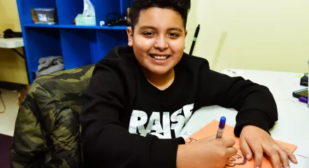 Child smiling and drawing.