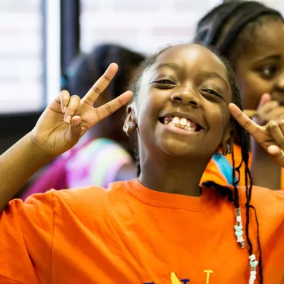 Girl smiling with peace sign