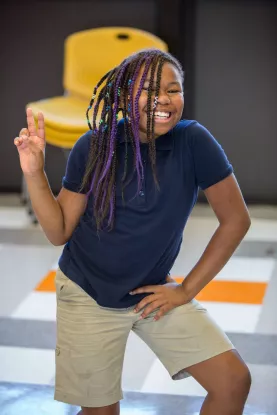 Youth posing making a peace sign with hands