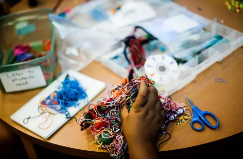 Hand holding colored string.