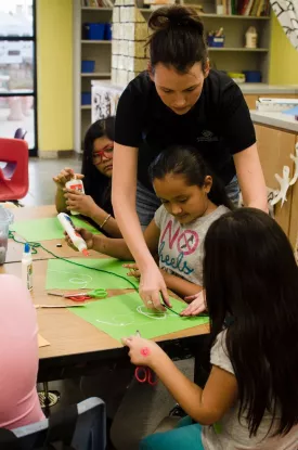 Youth creating art with support from a staff.