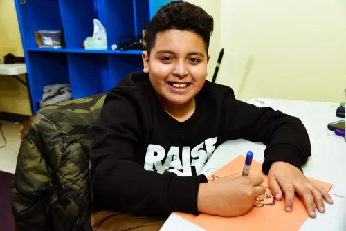 Child smiling and drawing.