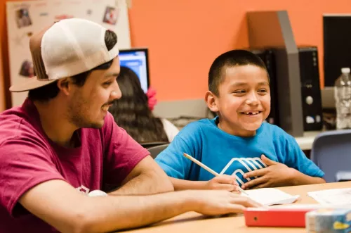 Youth and staff smiling, seated